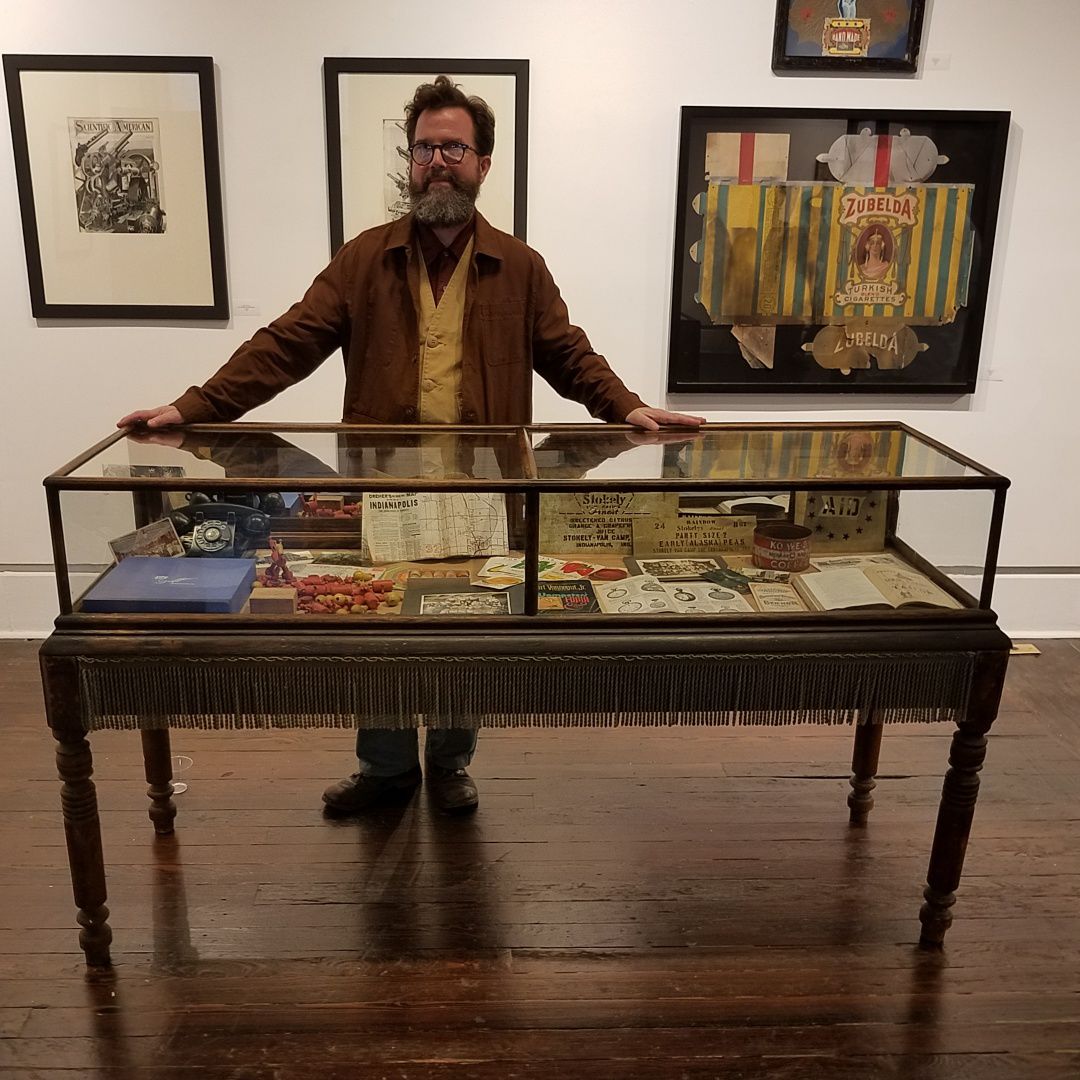 Kipp Normand with a display case in his exhibition 'Historicity'